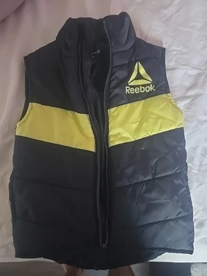 CHALECO REEBOK NEGRO Y AMARILLO CON LOGOTIPO VECTORIAL MODERNO  Foto 1 de 3