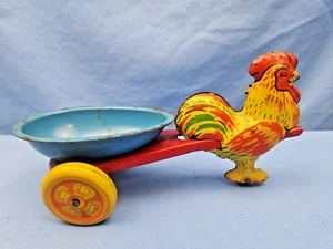 JUGUETES WYANDOTTE GALLO TIRANDO HUEVO AZUL CARRO HOJALATA JUGUETE - Imagen 1 de 9