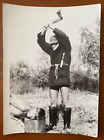 Mężczyzna z siekierą kotleci głowę faceta, facet w futrzanym płaszczu i botkach, zdjęcie vintage