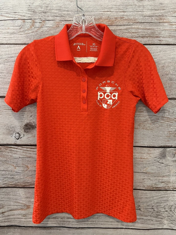 Polo de golf Antigua color rojizo/naranja PORCHE Club of America elástico para mujer XS Foto 1 de 4