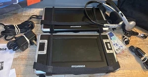 Sylvania Lettore DVD Portatile 7" Doppio Schermo con Borsa Trasporto/Remoto/Alimentatore - Foto 1 di 12