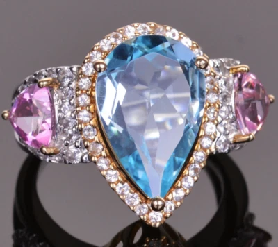 Con un anillo de topacio azul suizo en forma de pera de 7,18 quilates, dos rubíes rosados y circonitas blancas Foto 1 de 4