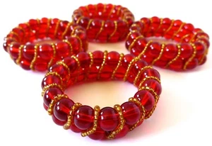 CUATRO SERVILLETEROS CON CUENTAS DE VIDRIO ROJO MESA CON PEQUEÑAS CUENTAS DE ACENTO DORADO.  - Imagen 1 de 6