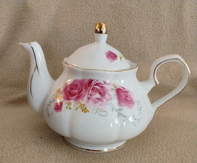 Tetera con decoración de rosa roja Foto 1 de 4