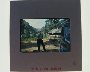 35mm Red Border Slide Montana 1953 Man Near Log Cabin By River Or Lake - Picture 1 of 2