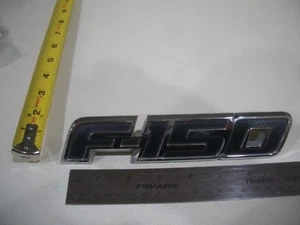 SÍMBOLO EMBLEMA ESCRITURA FORD F150 F-150 USADO BOLSA GUARDABARROS NEGRO CROMO OEM ORIGINAL - Imagen 1 de 2