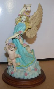 Figura de baile de ángel de pelo rubio con querubín sobre base de madera - Imagen 1 de 7