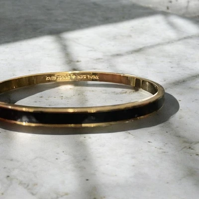 PULSERA "DRAW THE LINE" FIRMADA POR KATE SPADE OF NEW YORK ESMALTE NEGRO Y DORADO Foto 1 de 3