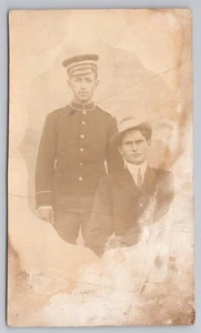 Postal RPPC Dos hombres en uniforme y traje c1918 - Imagen 1 de 2
