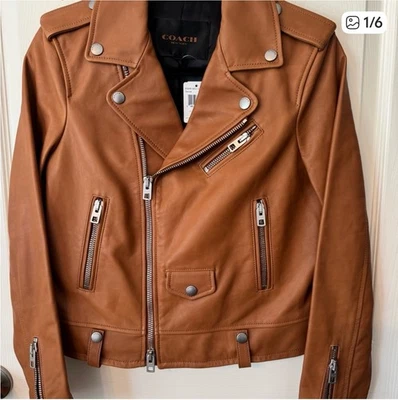 Elegante chaqueta de cuero marrón de Coach.Cuenta con múltiples cremalleras y botones a presión Foto 1 de 4