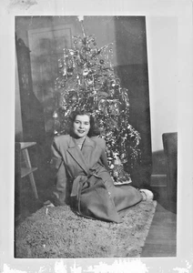 Schöne Frau sitzt 1948 vor geschmücktem Weihnachtsbaum ~ Foto 2-39D - Bild 1 von 2