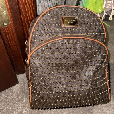 Mochila Michael Kors Jet Set Grande Marrón Oscuro con Tachuelas Doradas Firma Foto 1 de 4