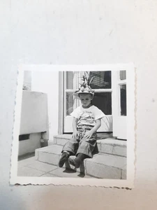 Foto instantánea vintage de los años 50 en blanco y negro 2 1/4" x 2 1/4" niño divertido sombrero en porche PB67 - Imagen 1 de 1