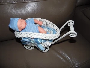 kleine Puppe mit blauer Bekleidung im Puppenwagen - Bild 1 von 5