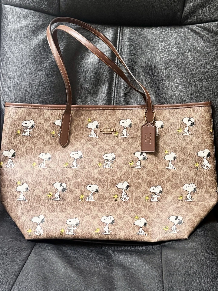 Coach X Peanuts City Tote Bag In Signature Canvas With Snoopy Print CBJ89 2025