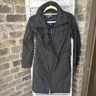 Gabardina de lluvia negra para mujer Cole Haan chaqueta con capucha oculta empacable pequeña Foto 1 de 4