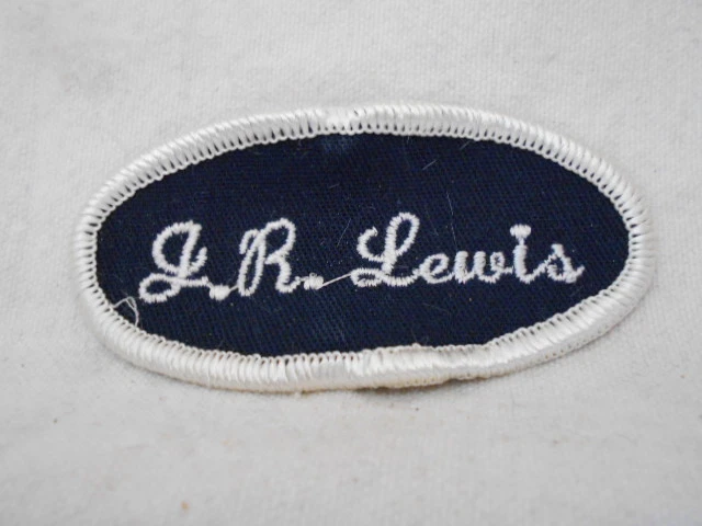 J.  R. LEWIS USED EMBROIDERED  SEW ON NAME PATCH TAG OVAL WHITE ON BLACK - Image 1 of 1