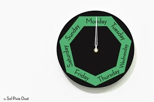 DayClocks - Reloj de pared hexagonal negro y azulado - Reloj del día de la semana - Reloj divertido - Imagen 1 de 4