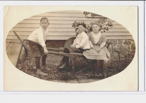 Real Photo Postcard RPPC - Two Boys and Girl and Wheelbarrow - Picture 1 of 2