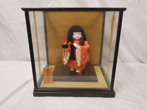 geisha doll in glass case