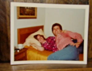 Found color Snapshot-Nerdy Guy in Checked Shirt Posing in Bed w/ Woman - Picture 1 of 2
