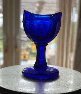 VINTAGE BLUE PEDESTAL GLASS EYE BATH - ELDER - FLOWER LOTION CO WITH EYE ON BASE - Picture 1 of 7