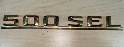 Distintivo modelo tampa traseira Mercedes-Benz - 126-817-06-15 - Para MBZ 500SEL 1981-1985 - Imagem 1 de 2
