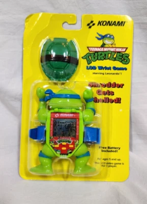 TMNT Teenage Mutant Ninja Turtles TRITURADORA CÁSCARA Konami LCD Muñeca Videojuego Foto 1 de 4