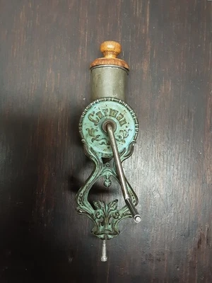 Antiguo molinillo de especias/café de hierro fundido con mango de madera montaje en mesa Foto 1 de 4