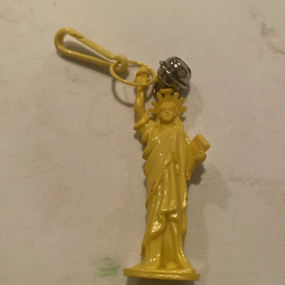 Collar vintage de la estatua de la libertad amarilla con dije de campana de plástico de los años 80 Foto 1 de 1