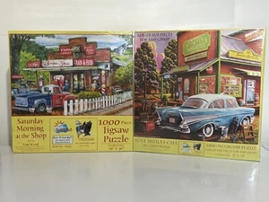 2 NEW Jigsaw Puzzles SunsOut 1000 Aunt Sheilas Café Saturday Morning At The Shop - Picture 1 of 1