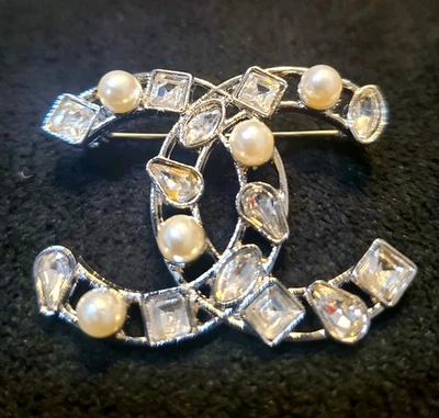 Broche de moda plateado con perlas y piedras transparentes. Foto 1 de 4