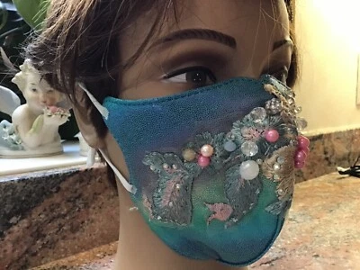 Mascarilla facial turquesa iridiscente con apliques de flores verdes y crema ¡brillos! Foto 1 de 4