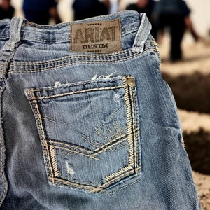 Pantalones de mezclilla Ariat tiro bajo para hombre 29x32 azul desteñido deshilachado costuras de bolsillo manchadas - Imagen 1 de 17