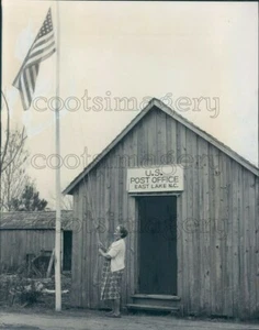 1956 Press Photo Woman Raises US Flag Wooden Post Office East Lake N Carolina - Picture 1 of 2
