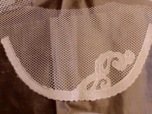 APLIQUE DE LINO BEIGE EN EL CUELLO DE MALLA INSERTADO EN LA ROPA - Imagen 1 de 3