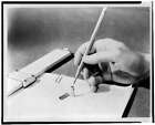 Photo:Hand Holding Pencil Over Transistor,Slide Rule 1949