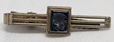 Clip de corbata vintage Anson tono dorado vidrio negro intaglio guerrero mediados de siglo... Foto 1 de 4