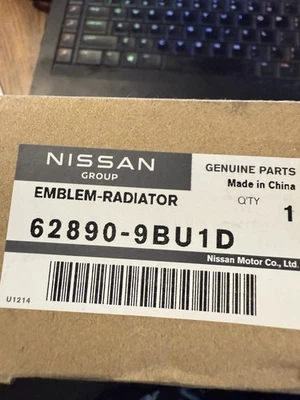 OEM NUEVO 2022-2025 Nissan Frontier Parrilla Delantera Emblema 62890-9BU1D NEGRO/ROJO Foto 1 de 4