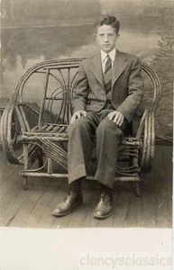 1944 Dick Zurhleen primo grande uomo tuta seduta sedia in vimini RPPC - Foto 1 di 1