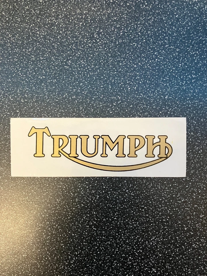 Triumph - 2 off vinyl self adhesive sticker 130x45mm (Gold & Black on clear) - Image 1 of 1