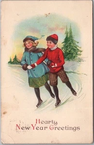 Postal vintage de FELIZ AÑO NUEVO / niño y niña patinaje sobre hielo al aire libre década de 1900 - Imagen 1 de 2