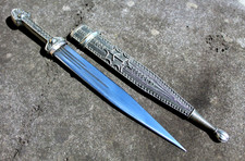 Caucasian qama or kindjal dagger, the 15cm pointed double edged blade with  centre fuller and two-piece horn grip; in nickel plated scabbard with  panels of figures and script L28.5cm overall; and east 