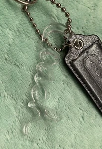 Coach Schlüsselanhänger Klar Kunststoff Kursiv Coach Metallic Leder Grau - Bild 1 von 4