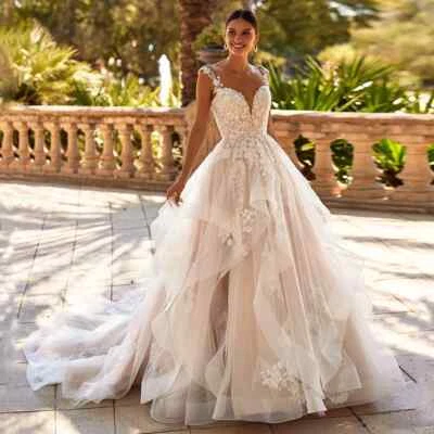 Vestido de novia de tul con apliques de encaje sin espalda con cuello en V sin mangas y volantes Foto 1 de 4