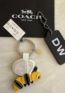 NUEVO CON ETIQUETAS LLAVERO COACH AMARILLO/MULTI FIRMA JACQUARD/MIXTO CUERO ABEJORRO ABEJORRO 92236 - Imagen 1 de 8