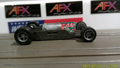 AFX RACING H.O. CHASIS ESTRECHO ESCALA MEGA G+ 1.7 CON LLANTAS GRISES DE 5 RADIOS CÁMARA ROJA Foto 1 de 4