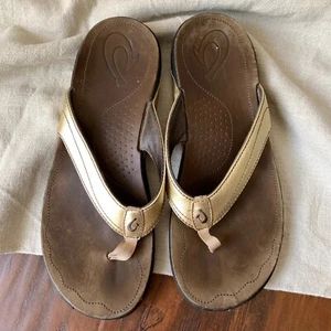 Sandalias chanclas de cuero dorado OLUKAI Kumu usadas en excelente estado estilo 20103 para mujer talla 10 - Imagen 1 de 8