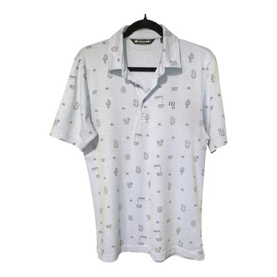 Camisa polo Travis Mathew para hombre pequeña azul panorámica para estampado de cactus dorados por todas partes Foto 1 de 4