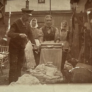 Antigua postal fotográfica RPPC hombre y mujer lavando la ropa usando mangle - Imagen 1 de 8